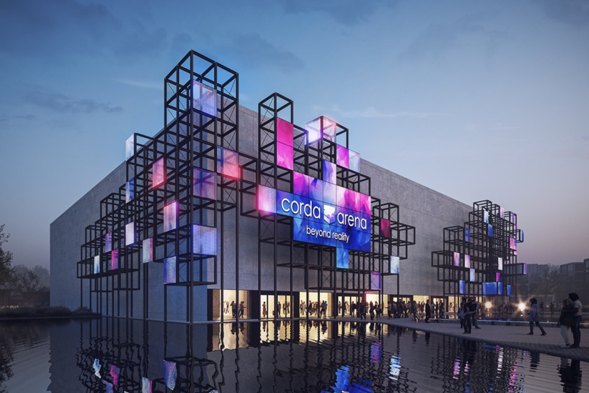 Corda Arena with illuminated cube facade Modern arena building with cube-frame LED lights glowing at dusk, reflected in water, with people at the entrance.